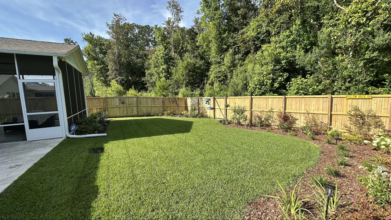 Freshly mowed backyard lawn with wooden fence