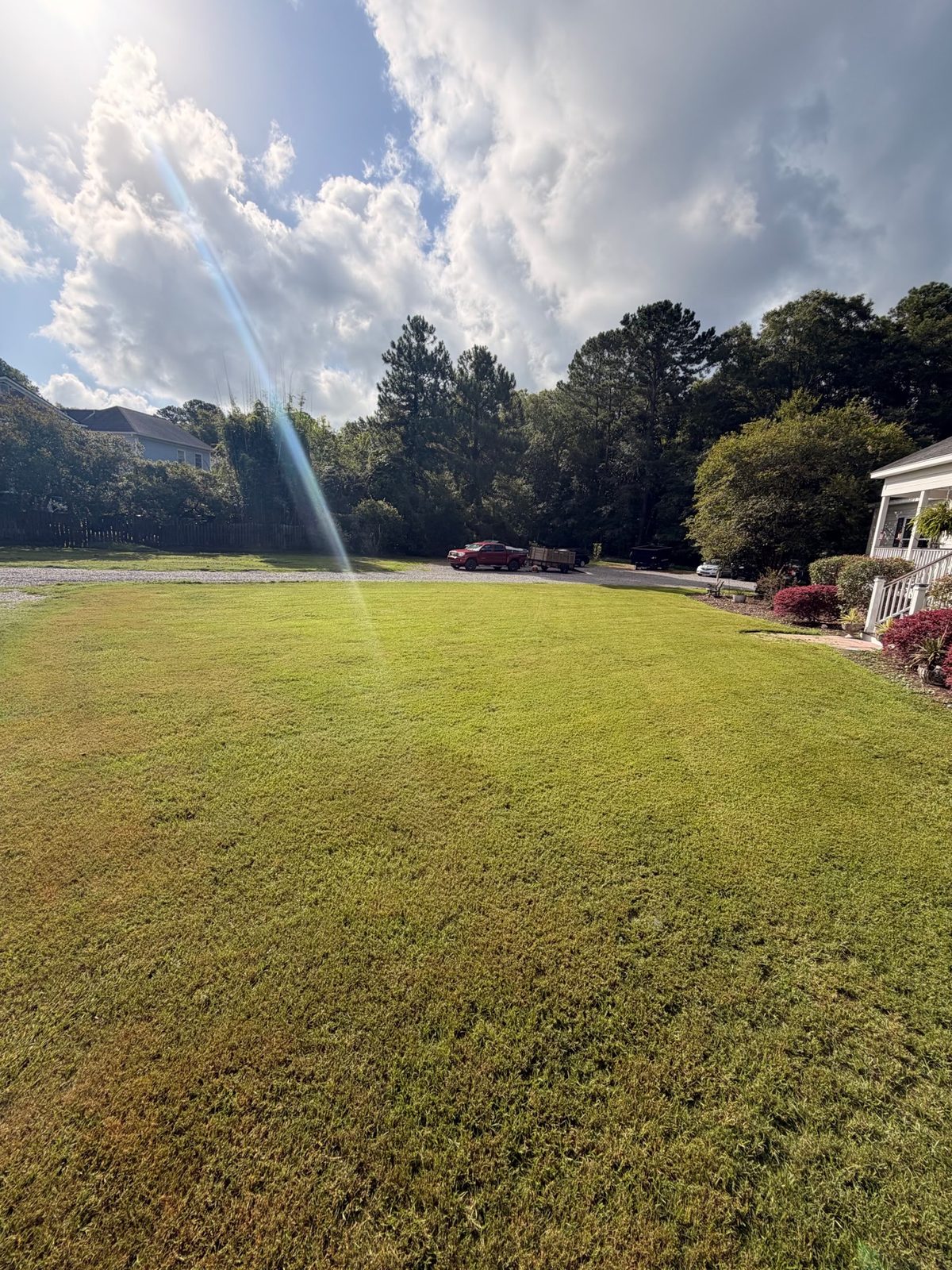 Wide freshly mowed lawn with work truck and trailer