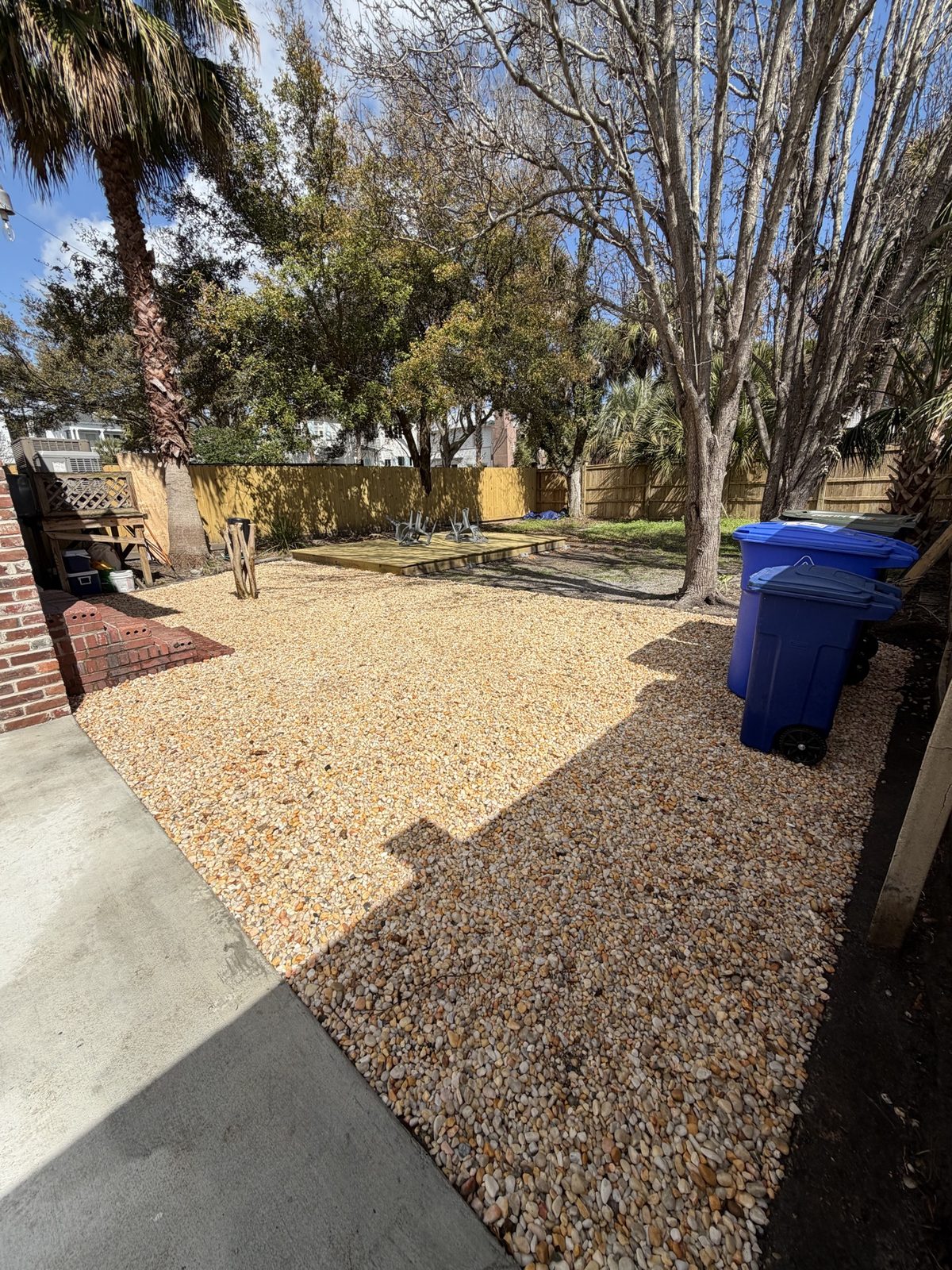 Rock ground cover installed in a backyard with palm trees
