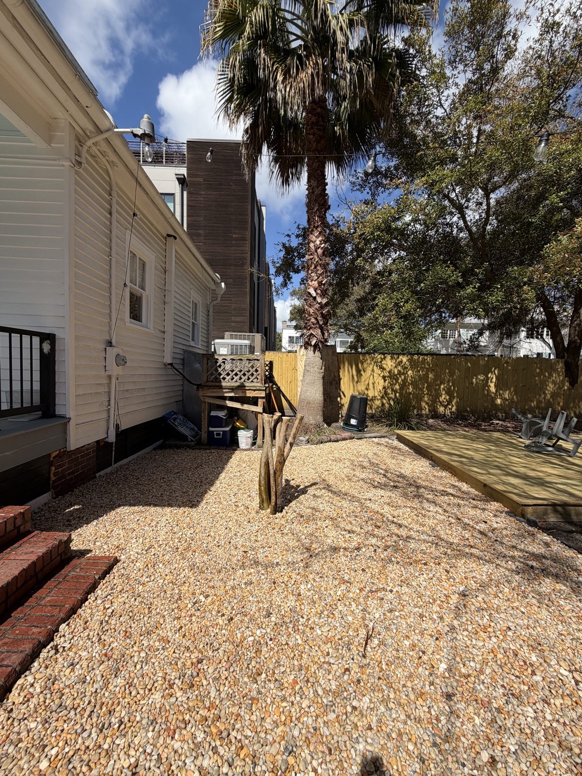 New rock installation beside a house with palm tree and deck